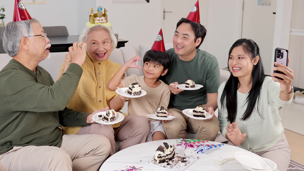 Family of three generations enjoys cake and captures moments with selfies in a festive, well-lit room
