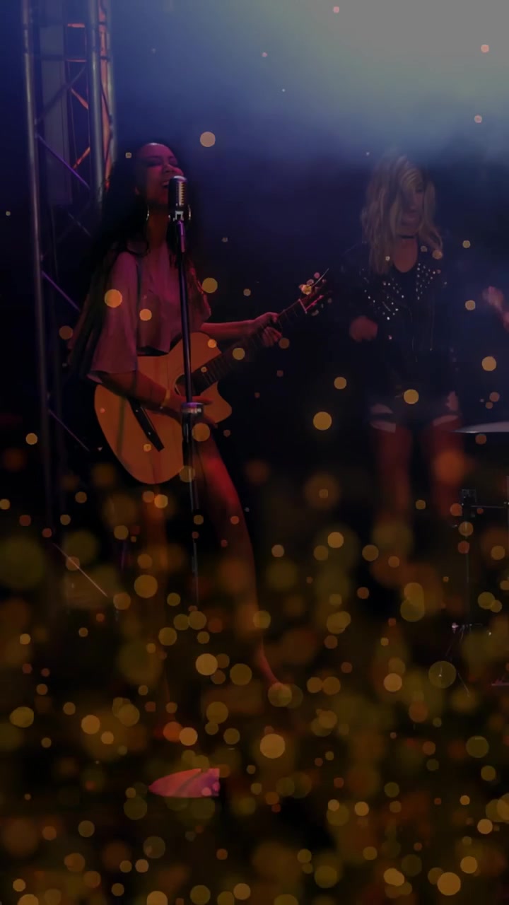 Vertikal video: Vokalist begynner å spille gitar, opptrer, bakgrunnssanger beveger seg, gyllen bokeh