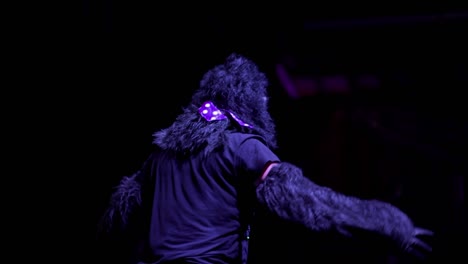 a performer in gorilla costume dancing in front of a crowd in a club