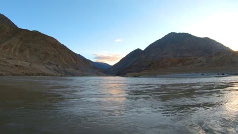 la confluencia y convergencia del río zanskar y el indo con montañas y sol al fondo