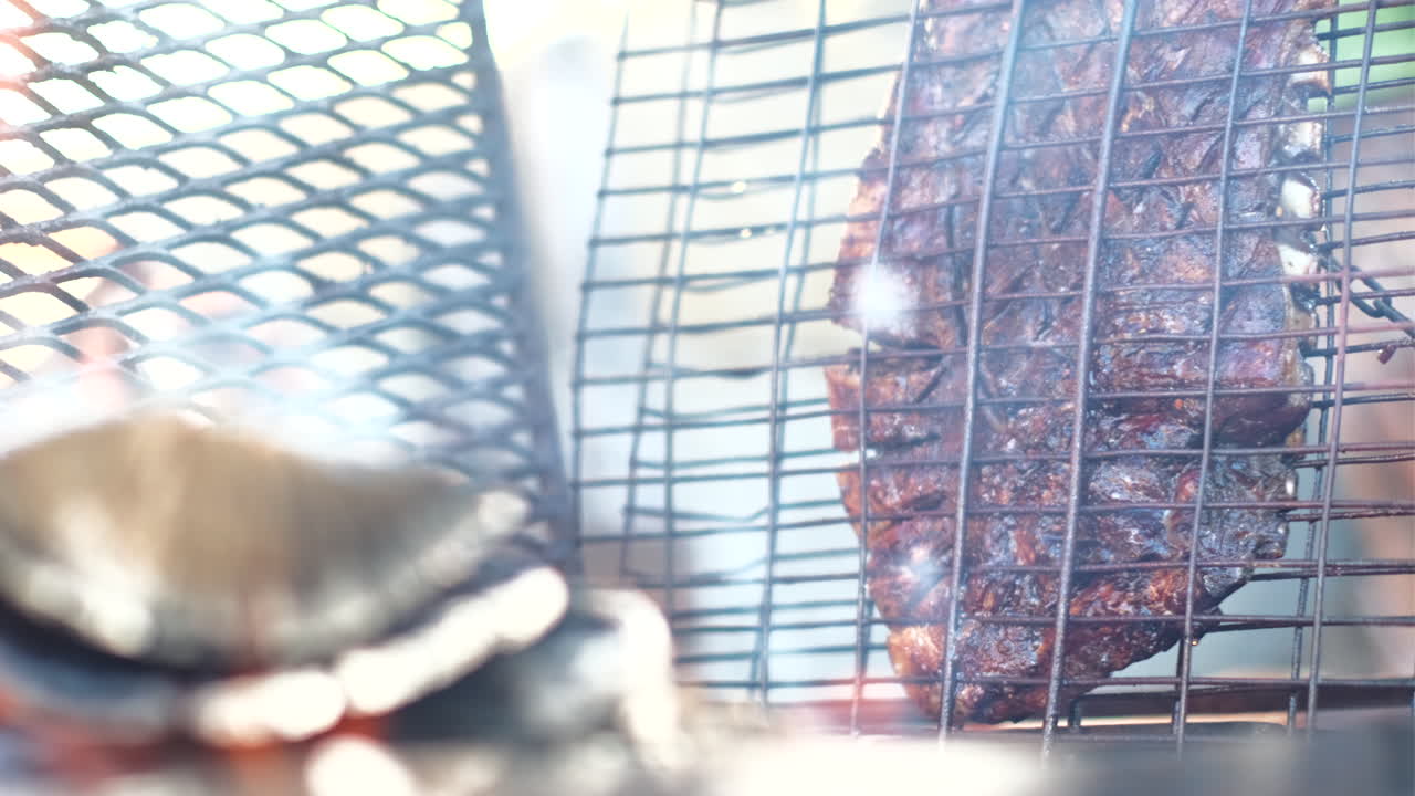 Costina di agnello succulenta che sfrigola, grigliata in verticale accanto a un fuoco a legna, Sudafrica