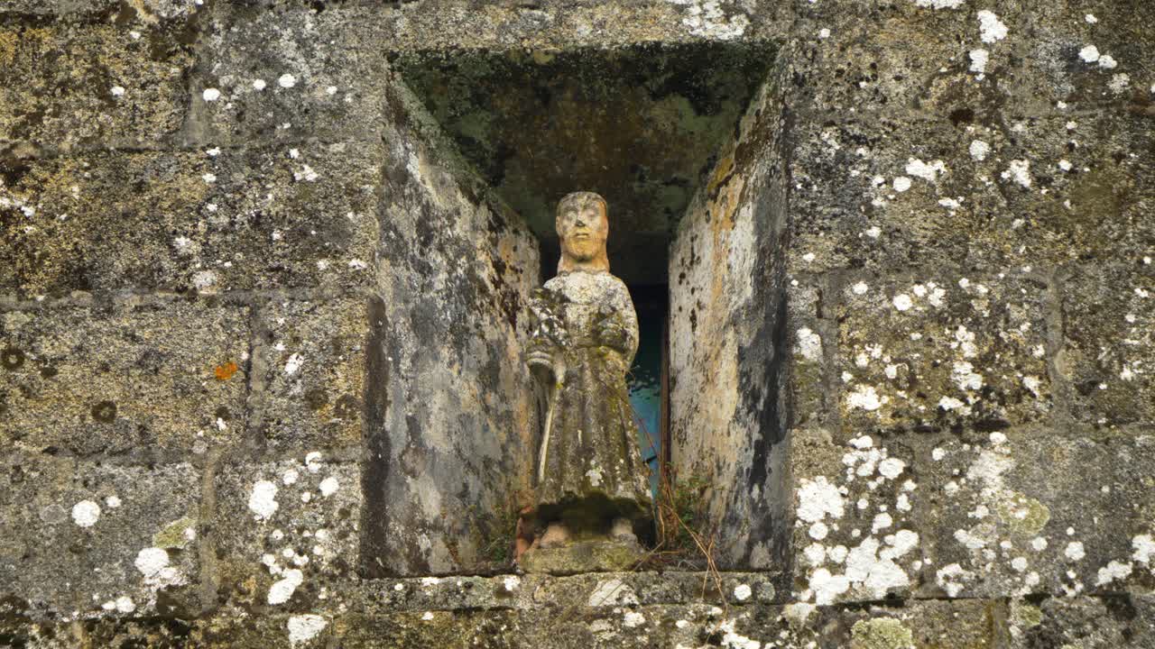 Stone statue detail on the facade of San Xillao de Rivela church in Coles, Ourense, Galicia, Spain