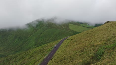 road near miradouro caldeira rasa e funda with low clouds, aerial