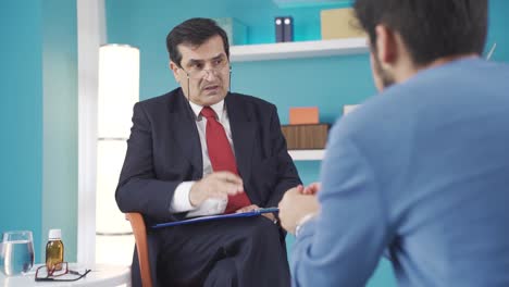 dokter psychotherapeut zit op een stoel en praat met een patiënt in een psychotherapiesessie.