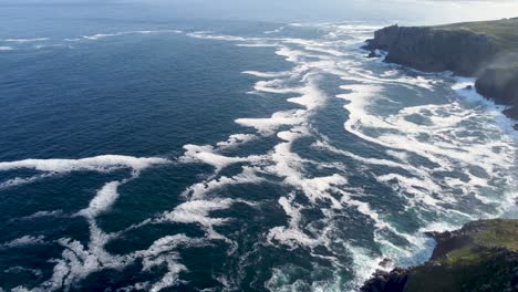 imágenes de drones de 4k de acantilados del extremo de la tierra con una pequeña isla con olas y niebla marina