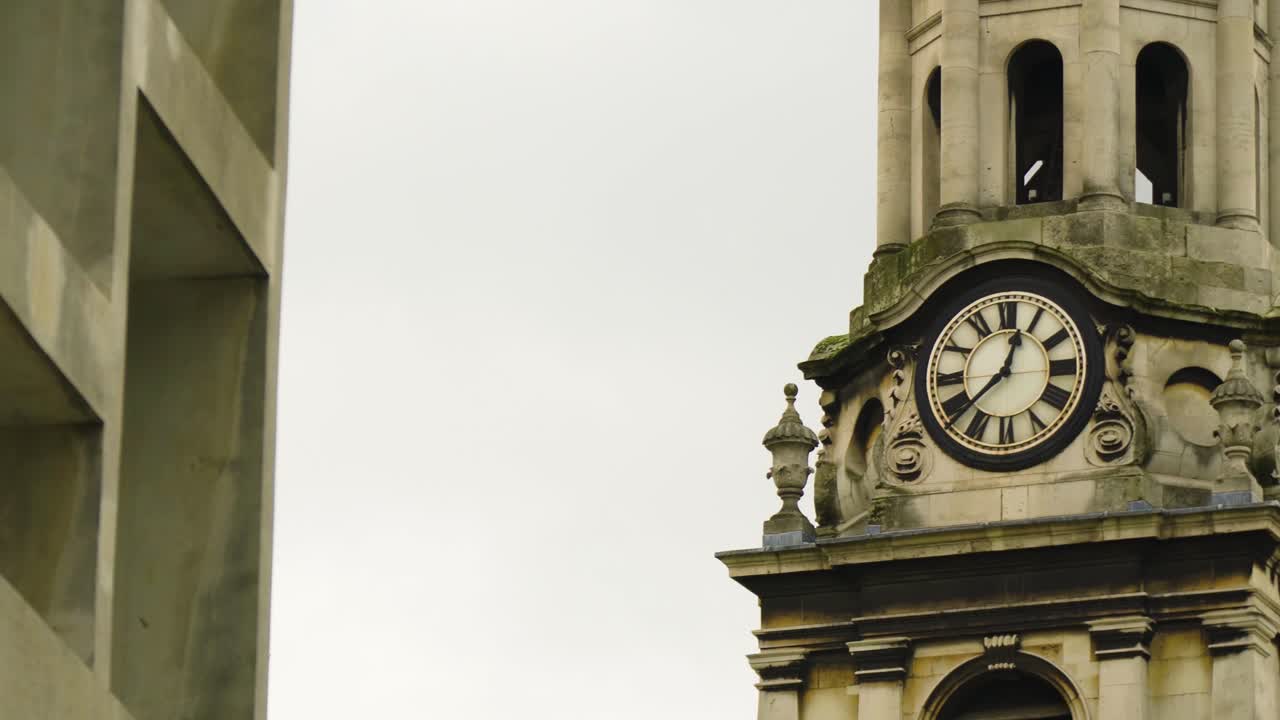 historic round clock tower building with roman numeral custom hand made numbers moving cinematic shot afternoon time located in London moody dramatic scenery