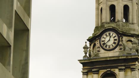 historic round clock tower building with roman numeral custom hand made numbers moving cinematic shot afternoon time located in london moody dramatic scenery