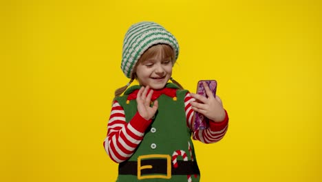 Kind,-Mädchen-Im-Weihnachtselfen-Weihnachtsmann-Helferkostüm,-Das-Einen-Videoanruf-Auf-Dem-Mobiltelefon-Tätigt