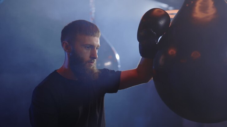Uomo che pratica boxe con sacco da boxe