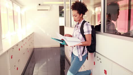 estudiante bonita revisando y sonriendo a la cámara con los pulgares hacia arriba