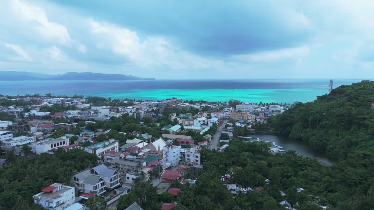 Sweeping aerial of Boracay’s vibrant town, lush green hills, and turquoise ocean. Ideal for travel, tourism, real estate, and tropical lifestyle projects