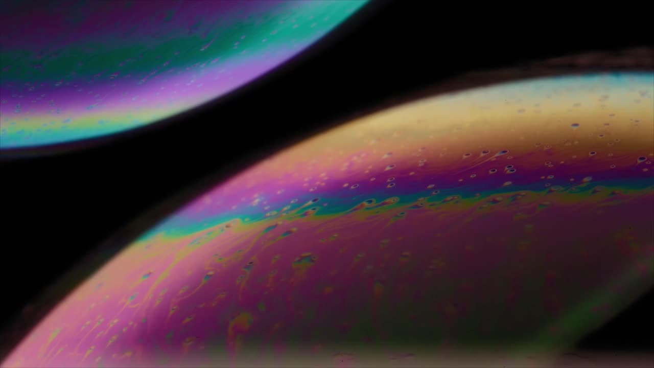 Vista macro di bolle di sapone iridescenti e colorate su sfondo nero