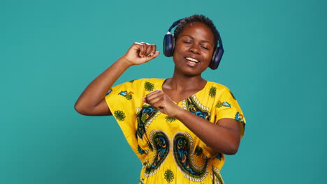 young adult having fun dancing and listening to her music in studio