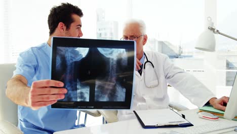 male doctor and coworker examining x-ray