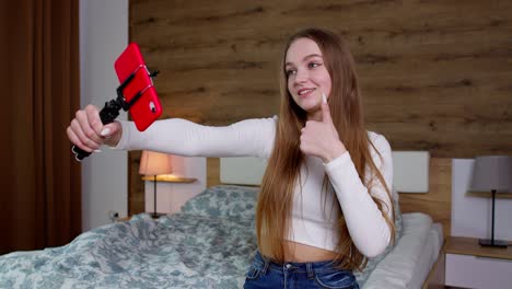 Lächelndes,-Süßes-Vlogger-Mädchen,-Das-Auf-Das-Handy-Schaut,-Einen-Videoanruf-Macht-Und-Zu-Hause-Einen-Vlog-Macht-Und-Ein-Selfie-Macht