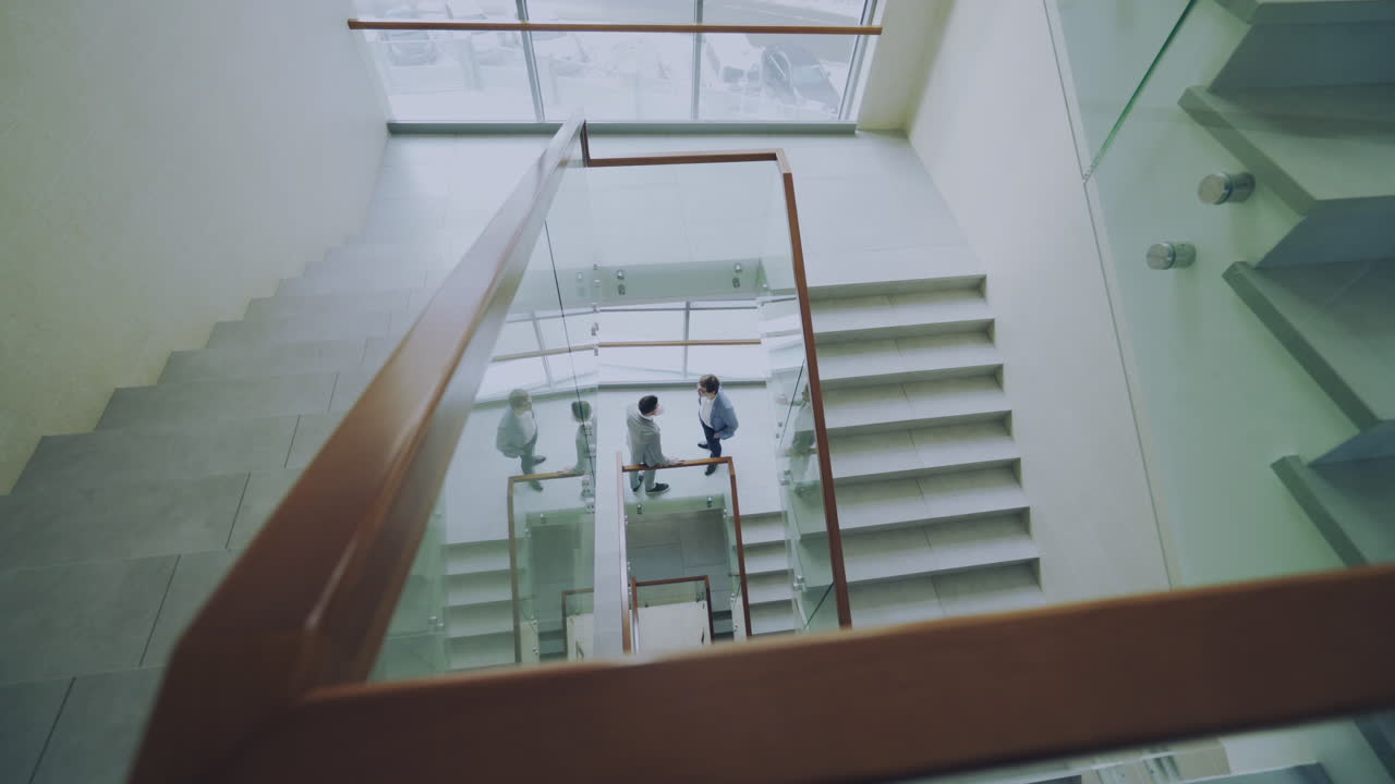 Business People Meeting on Spiral Staircase in Modern Office Building