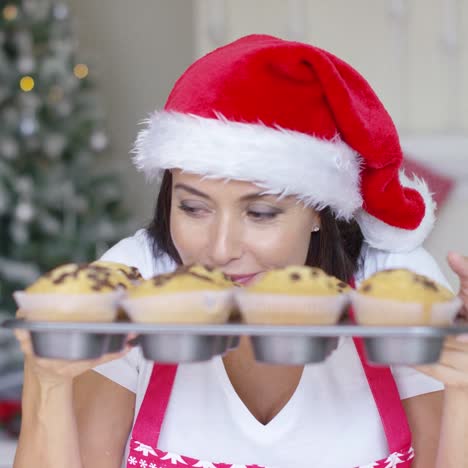 smiling woman with a tray of freshly baked cakes