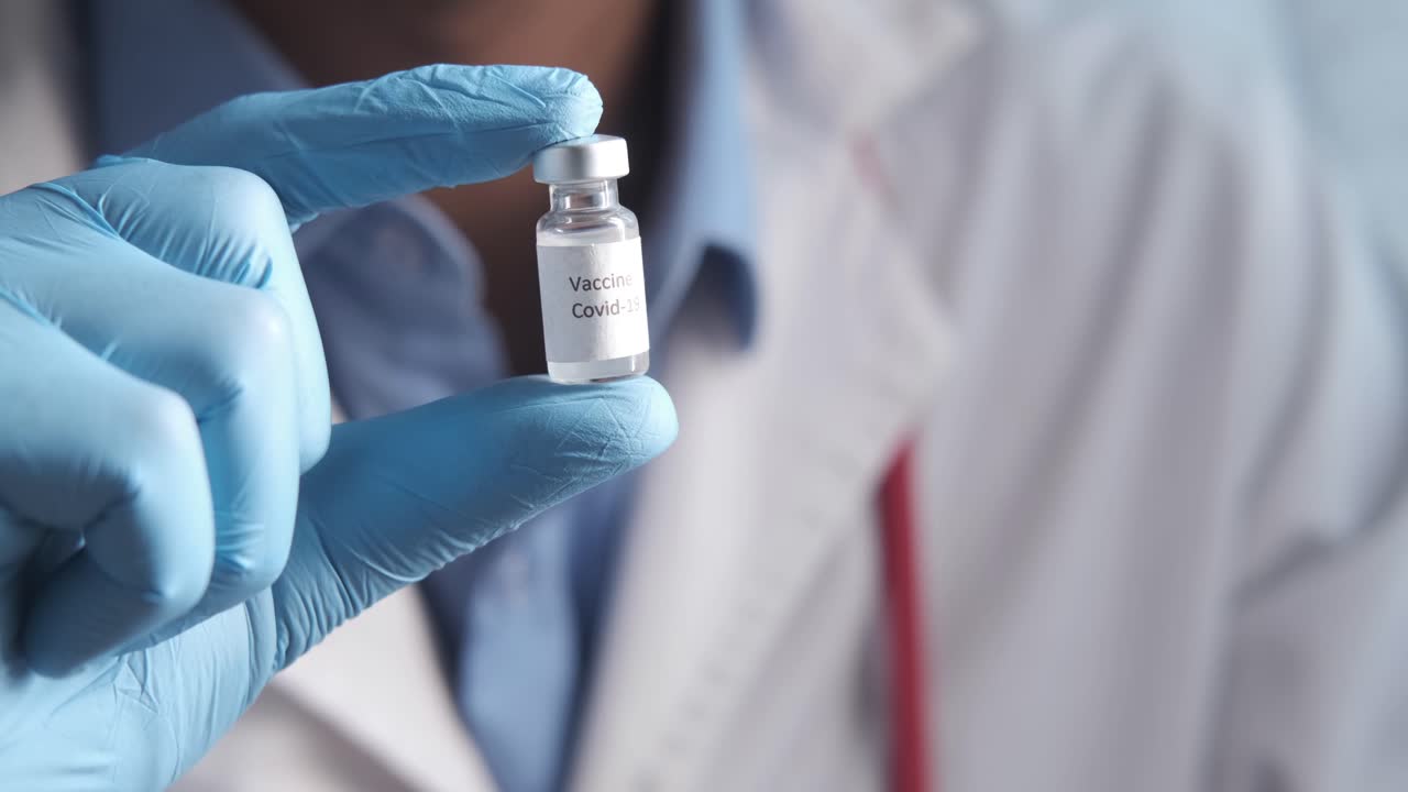 médico con un vial de la vacuna contra el covid-19