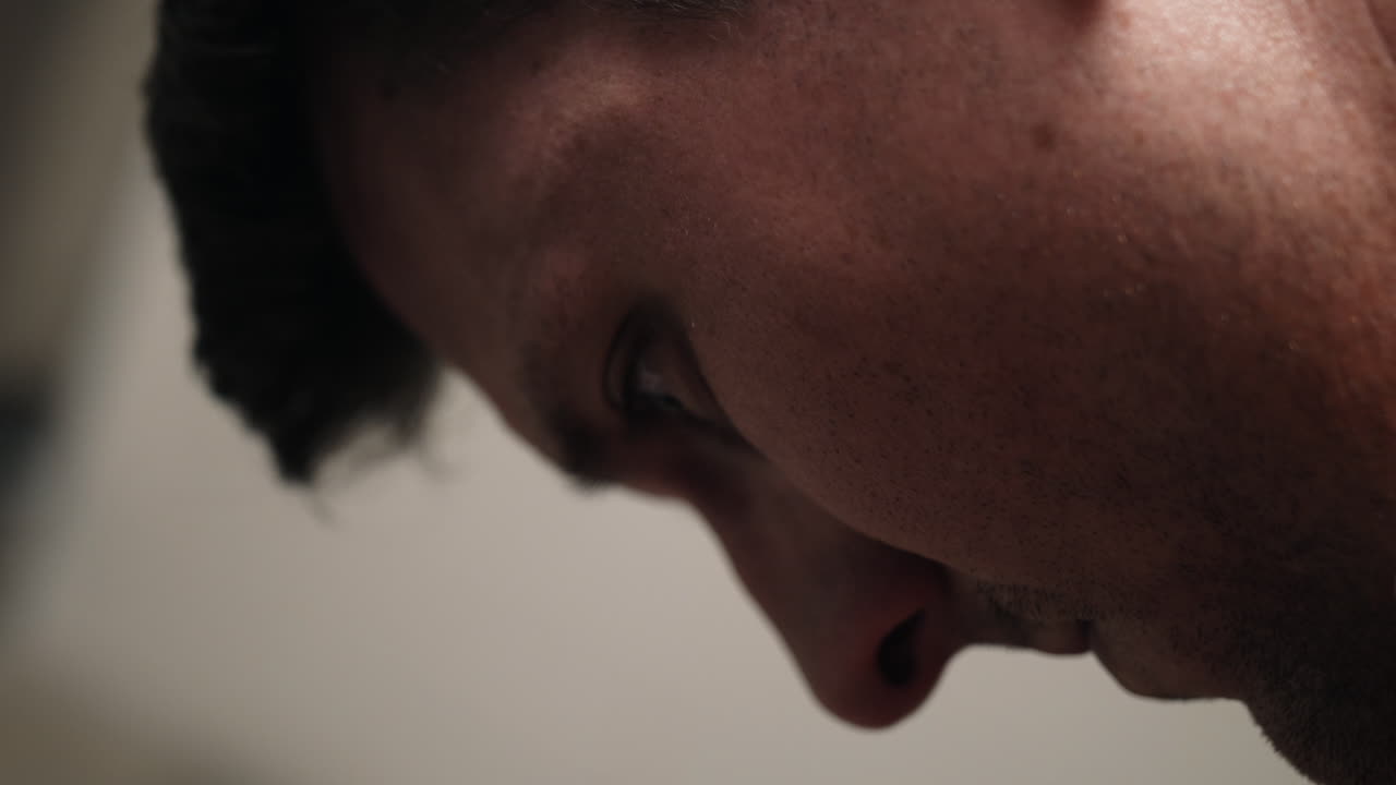 슬프고 우울한 매력적이고 잘생긴 남자의 얼굴, 범죄 죄수, 감옥에 앉아있는 오렌지색 정복을 입은 죄수