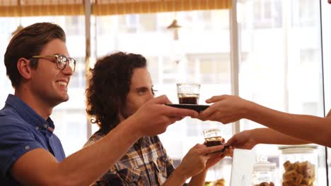 waitress serving black tea to two friends