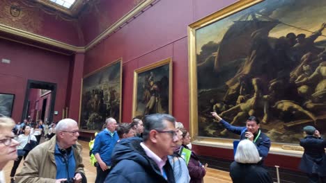 visitors observing and discussing famous paintings