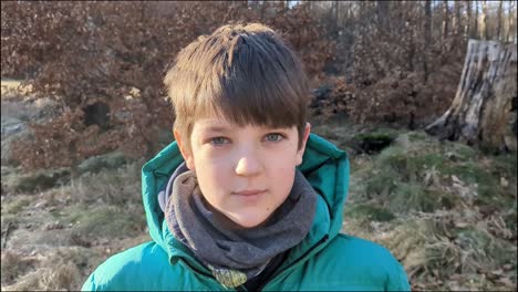 Boy-Standing-in-Clearing-in-the-Woods-Looking-at-Camera,-Portrait-of-Boy