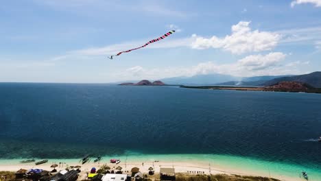 Vista-Aérea-De-La-Isla-De-Kenawa,-Sumbawa,-Indonesia,-Drone-Cerca-De-La-Cometa-Que-Vuela-Sobre-El-Archipiélago-Que-Revela-Un-Impresionante-Paisaje-Marino-Tropical-De-Naturaleza-Salvaje-Para-El-Destino-De-Vacaciones