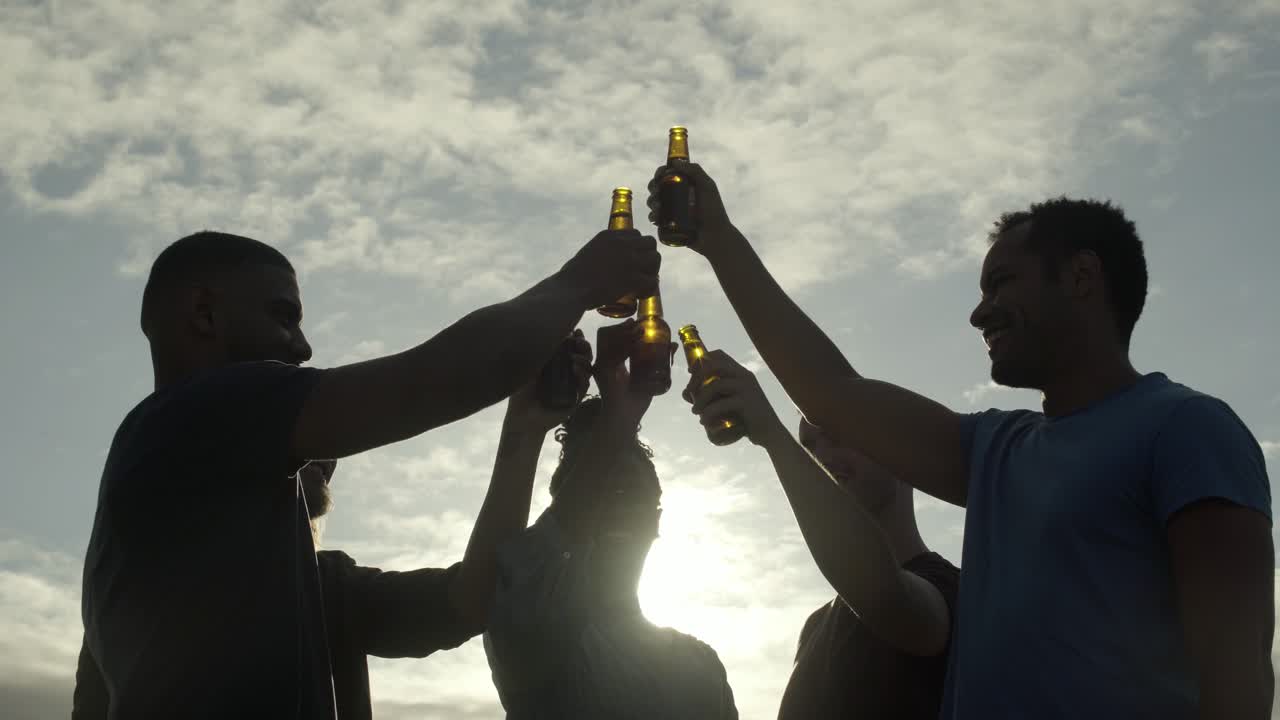 amigos sonrientes animando con botellas de cerveza y hablando