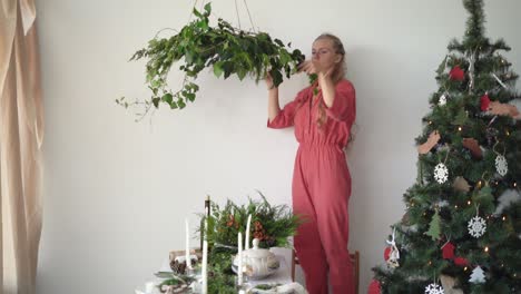 woman florist dressed in overalls makes a wreath. christmas preparation concept...