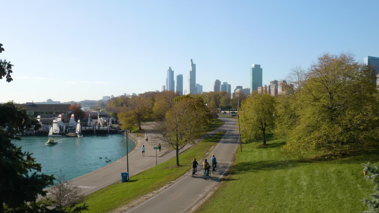 gente corriendo y montando en bicicleta en el camino frente al lago de chicago en un hermoso día de otoño