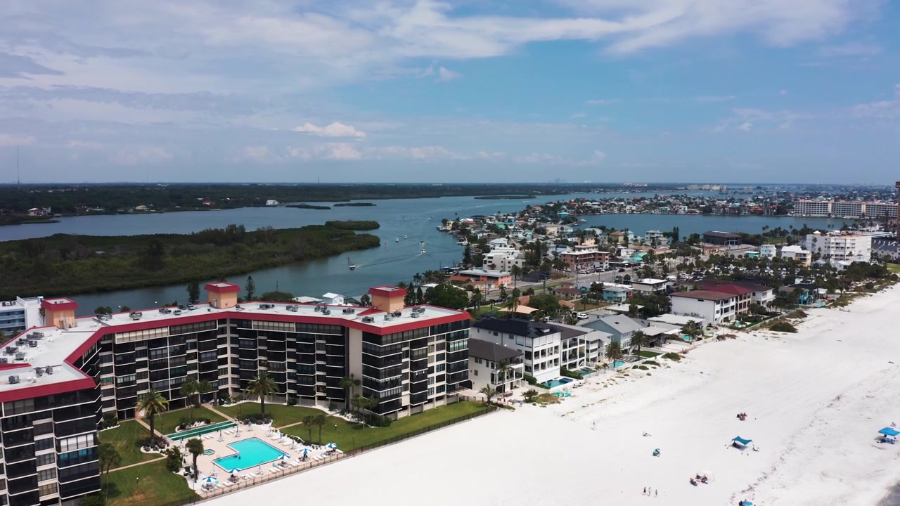 Grattacieli costeggiano una spiaggia di sabbia bianca incontaminata con uno sfondo di acque calme e isole lontane. Ideale per contenuti immobiliari o di viaggio.