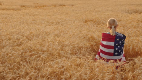 Woman-With-Usa-Flag-On-Her-Shoulders-Stands-In-A-Wheat-Field-Top-View