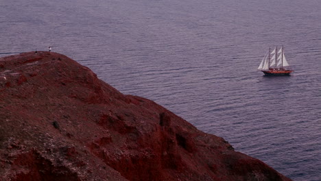 a beautiful sailing ship sails near some islands at dusk