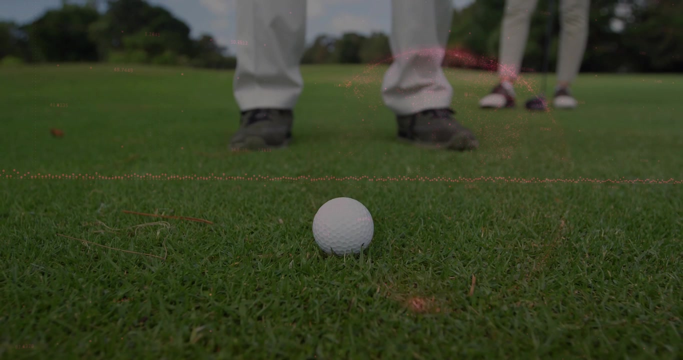 Viser golfball på peg, mann i lyse bukser forbereder slag, partner står, en spent snor.