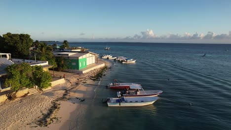 a calm aerial view of a beach with boats at gran roque during sunrise, serene atmosphere