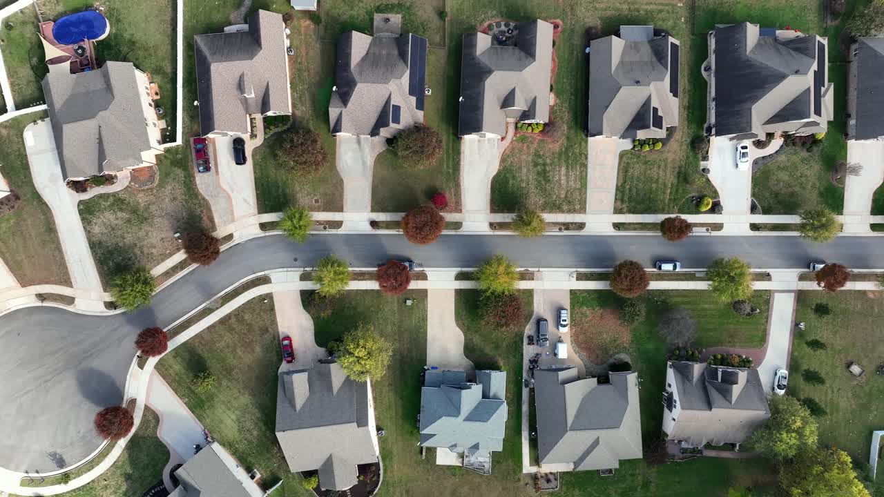 Colored trees along road of luxury neighborhood with villas and mansion. Aerial top down shot. Peaceful suburb residential area in America at fall season. Large property and real estates