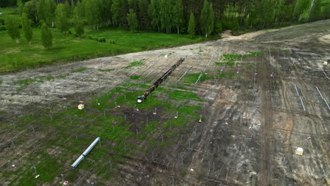 aerial orbit construction site of new solar farm in a cleared forest area