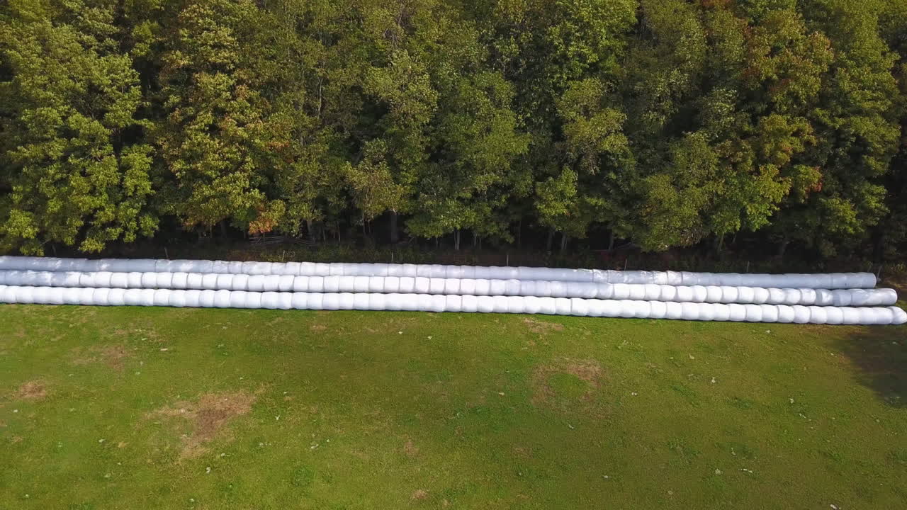 vista aérea de drones de fardos de heno apilados en un campo agrícola después de la cosecha
