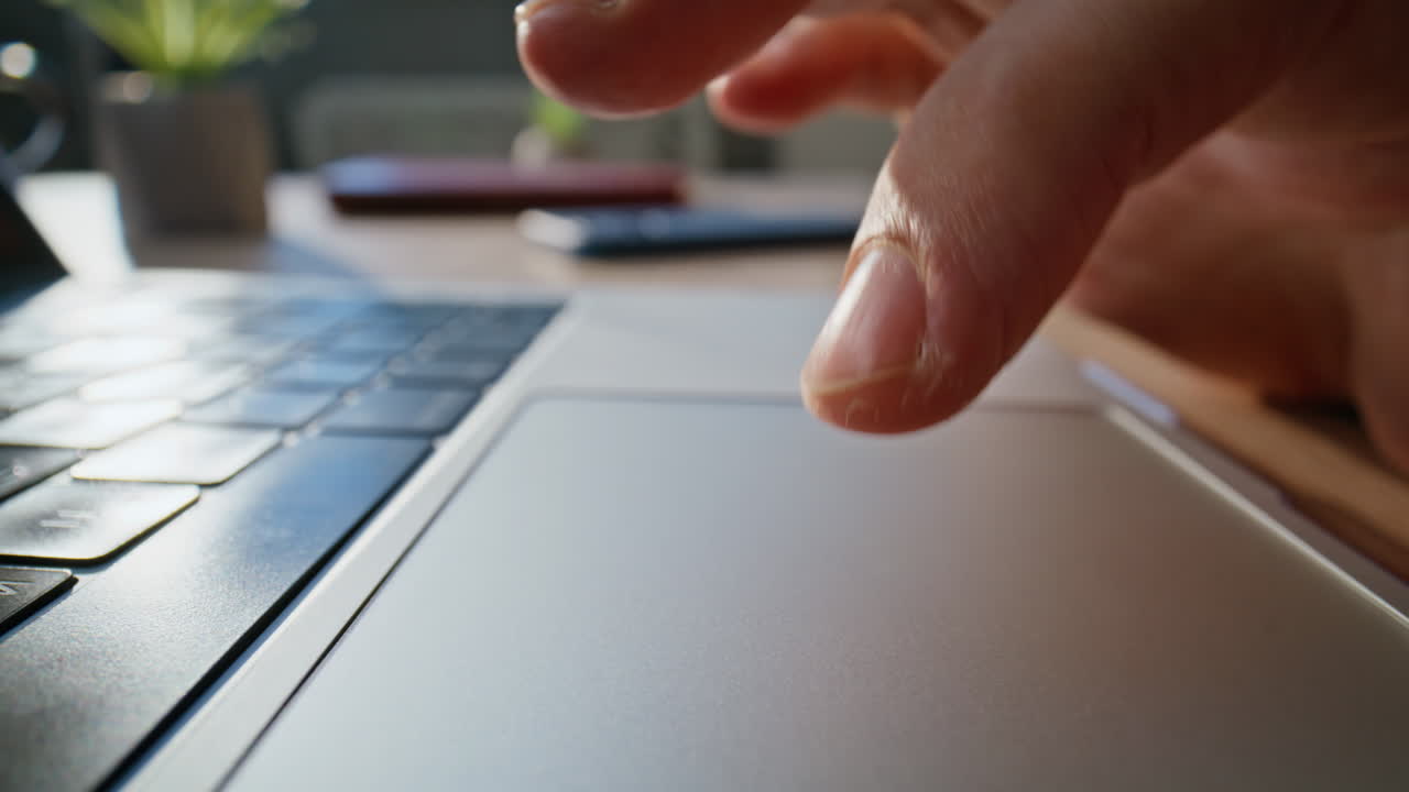 Closeup hand using touchpad laptop in workspace. Macro shot unknown businessman