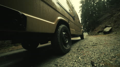 off-road van driving on a forest gravel road in the rain