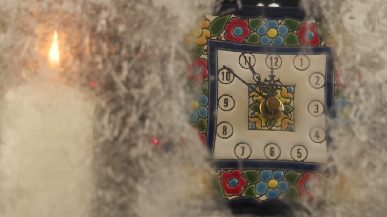 불의 불꽃이 움직이는 손으로 시계 다이얼을 비추고, 크리스마스 장식