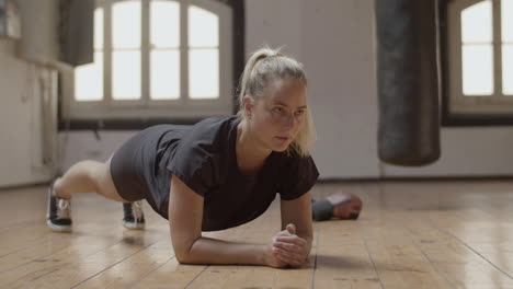 long shot of focused and fit woman making plank exercise