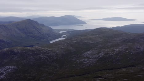 Drone-shot-of-the-landscape-and-distant-seascape-around-the-Clisham-mountain-on-the-Isle-of-Harris,-part-of-the-Outer-Hebrides-of-Scotland