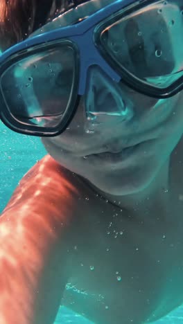 un niño bajo el agua se divierte en la piscina.