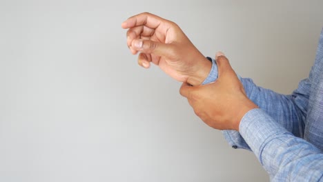 hombre sosteniendo su muñeca en dolor