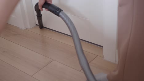 woman vacuuming the floor in a house