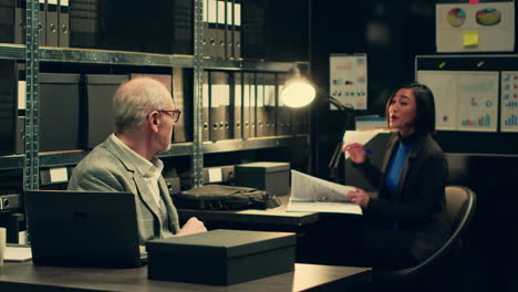 senior detective asking his partner about legal documents in archive room