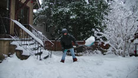 a man clears the driveway to a house from snow with a shovel