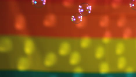 burbujas flotando contra la bandera del arco iris