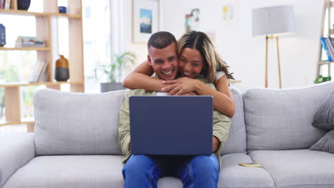 portátil, abrazo y pareja sonriendo en el sofá en casa